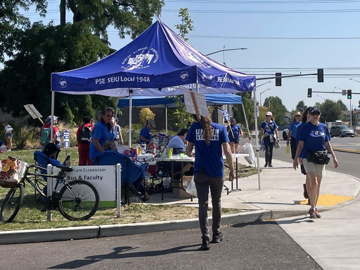 Tents set up outside Mill Plain Elementary with signs, sign-up sheets, and food & beverages