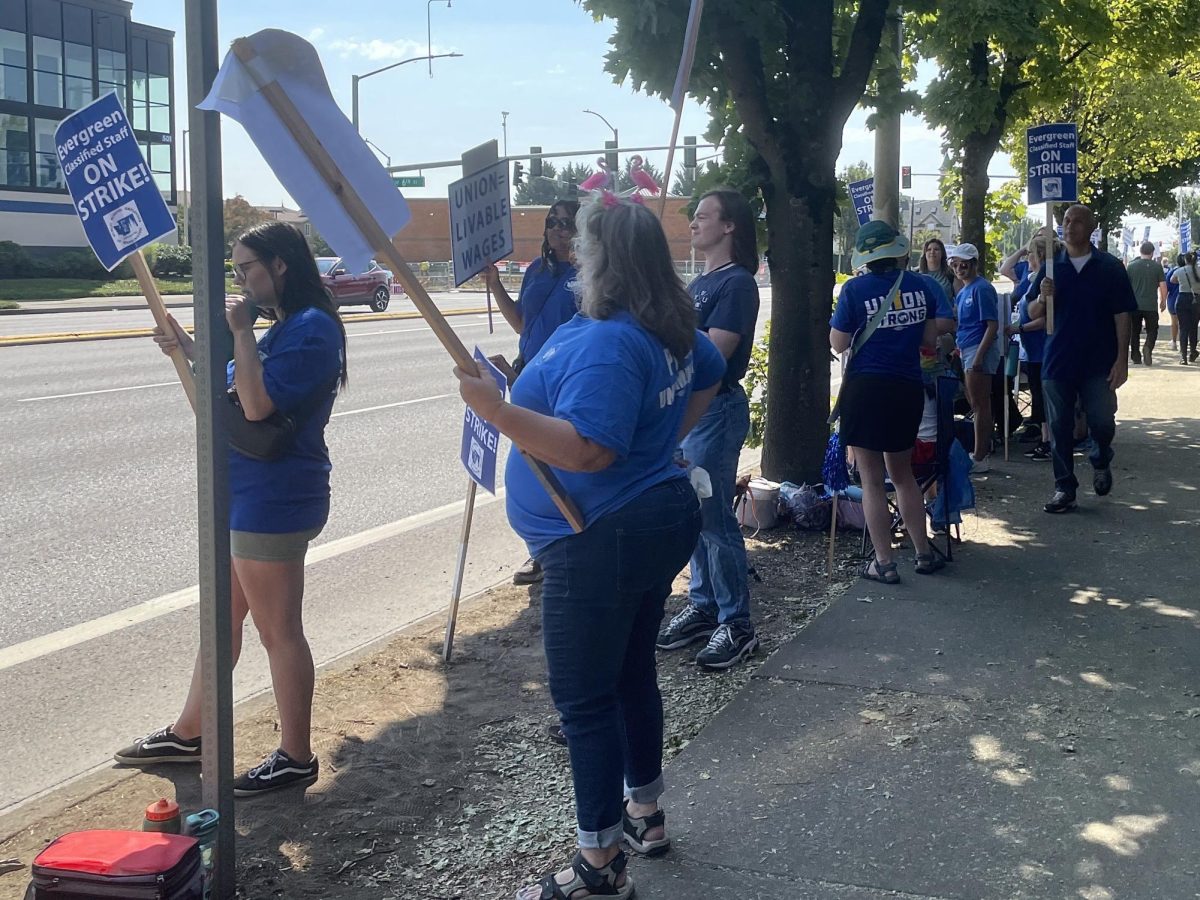 Staff holding many signs on the side of the road